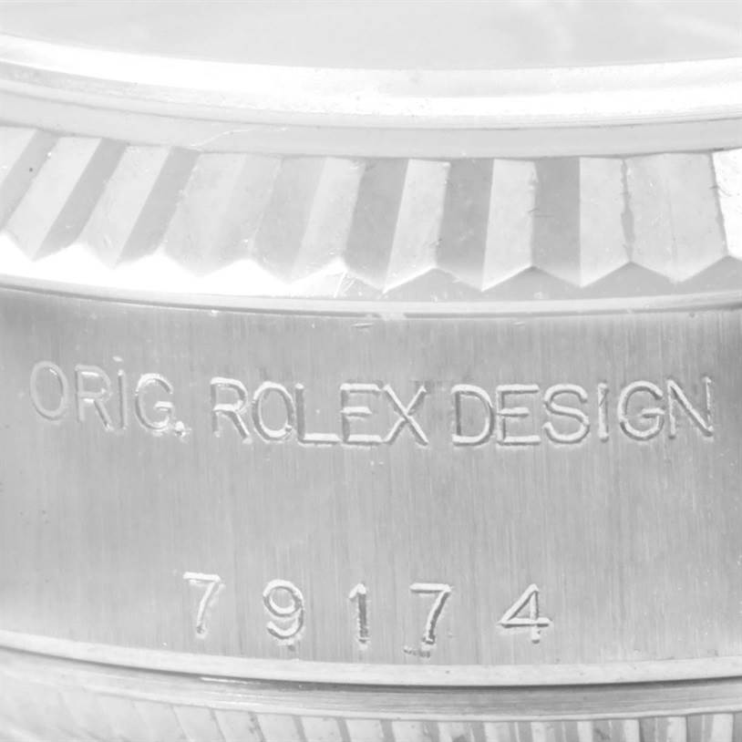 The image shows a close-up angle of the serial number and "ORIG. ROLEX DESIGN" engraving on the bezel of a Rolex Datejust 79174 Women's Stainless Steel Blue Dial 79174 Women's Stainless Steel Blue Dial watch.