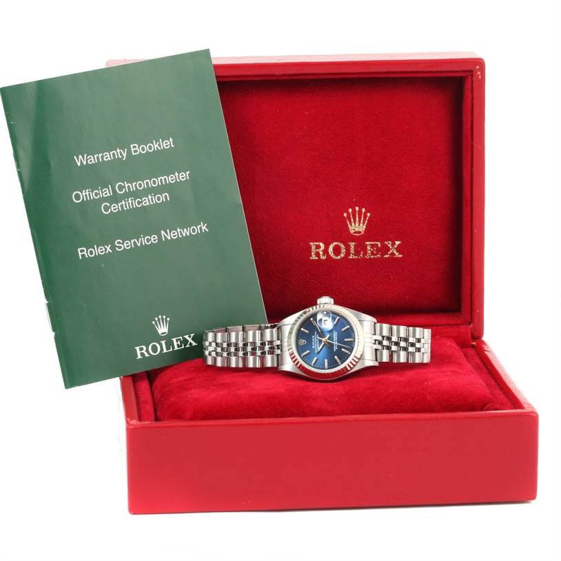 The image shows a Rolex Datejust 79174 Women's Stainless Steel Blue Dial 79174 Women's Stainless Steel Blue Dial watch, displayed in its red box with a warranty booklet standing beside it.