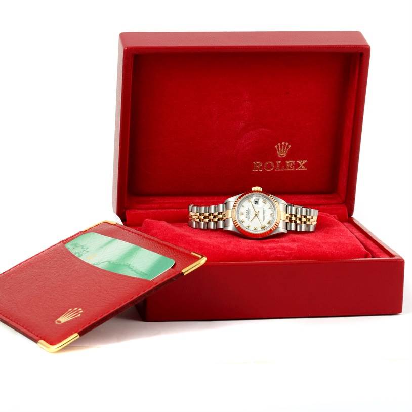 The Rolex Datejust 79173 Women's Stainless Steel White Dial 79173 Women's Stainless Steel White Dial watch is displayed frontally in its red case with a matching document holder beside it.