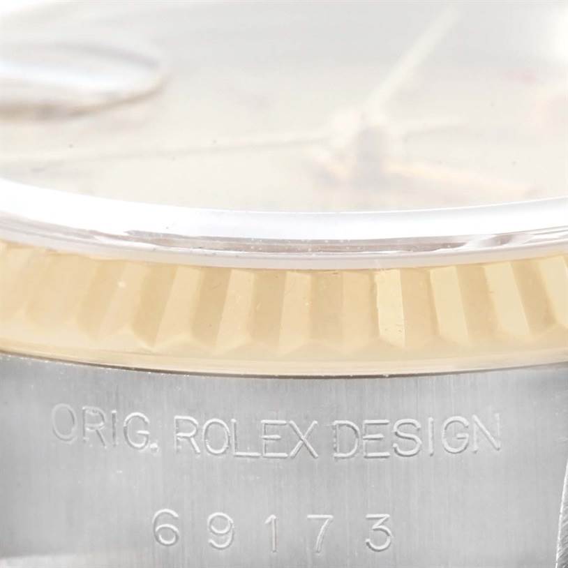 The image shows an angled close-up of the side of a Rolex Datejust 69173 Women
s Stainless Steel Champagne Dial 69173 Women
s Stainless Steel Champagne Dial watch, focusing on the bezel and engraved numbers "69173."