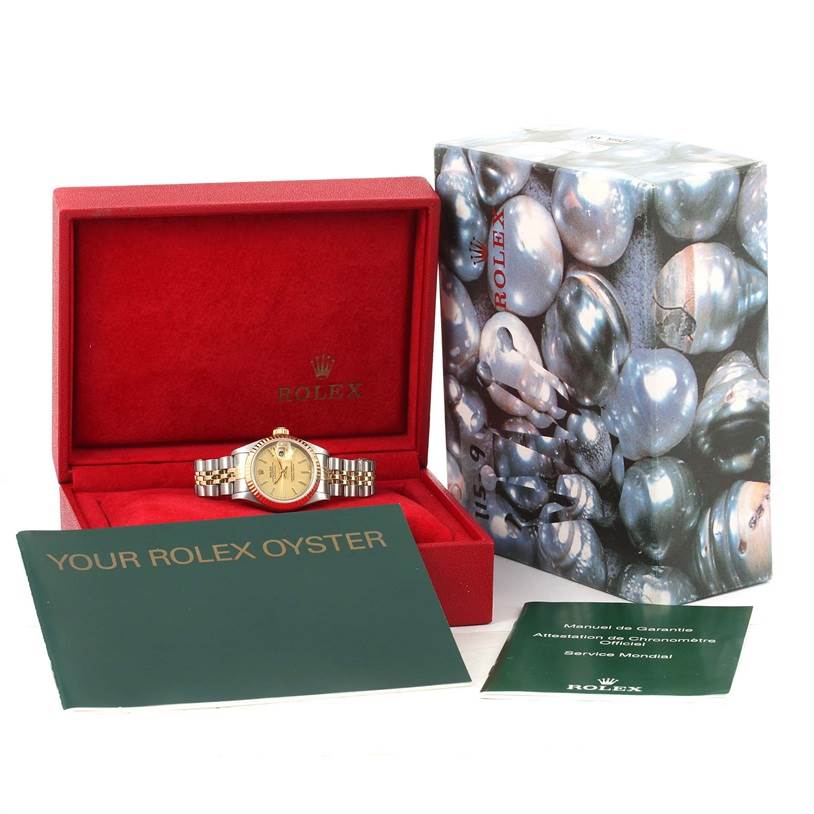 The Rolex Datejust 69173 Women
s Stainless Steel Champagne Dial 69173 Women
s Stainless Steel Champagne Dial watch is displayed in an open red box with accompanying manuals and the outer packaging.