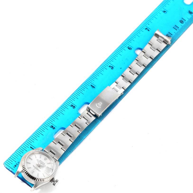 The image shows a Rolex Datejust 79174 Women
s Stainless Steel Silver Dial 79174 Women
s Stainless Steel Silver Dial watch laid flat next to a blue ruler, focusing on the bracelet and clasp.