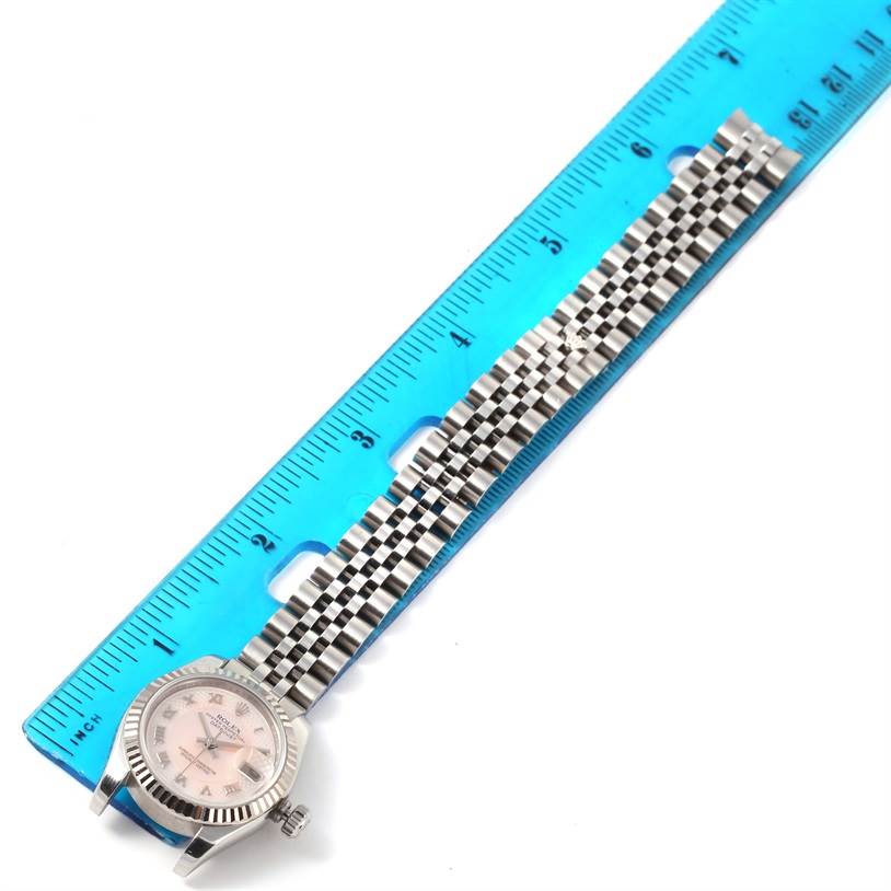 This image shows a Rolex Datejust 179174 Women's Stainless Steel Mother of Pearl Dial 179174 Women's Stainless Steel Mother of Pearl Dial watch laid flat next to a ruler, with the bracelet and dial visible from a top view.