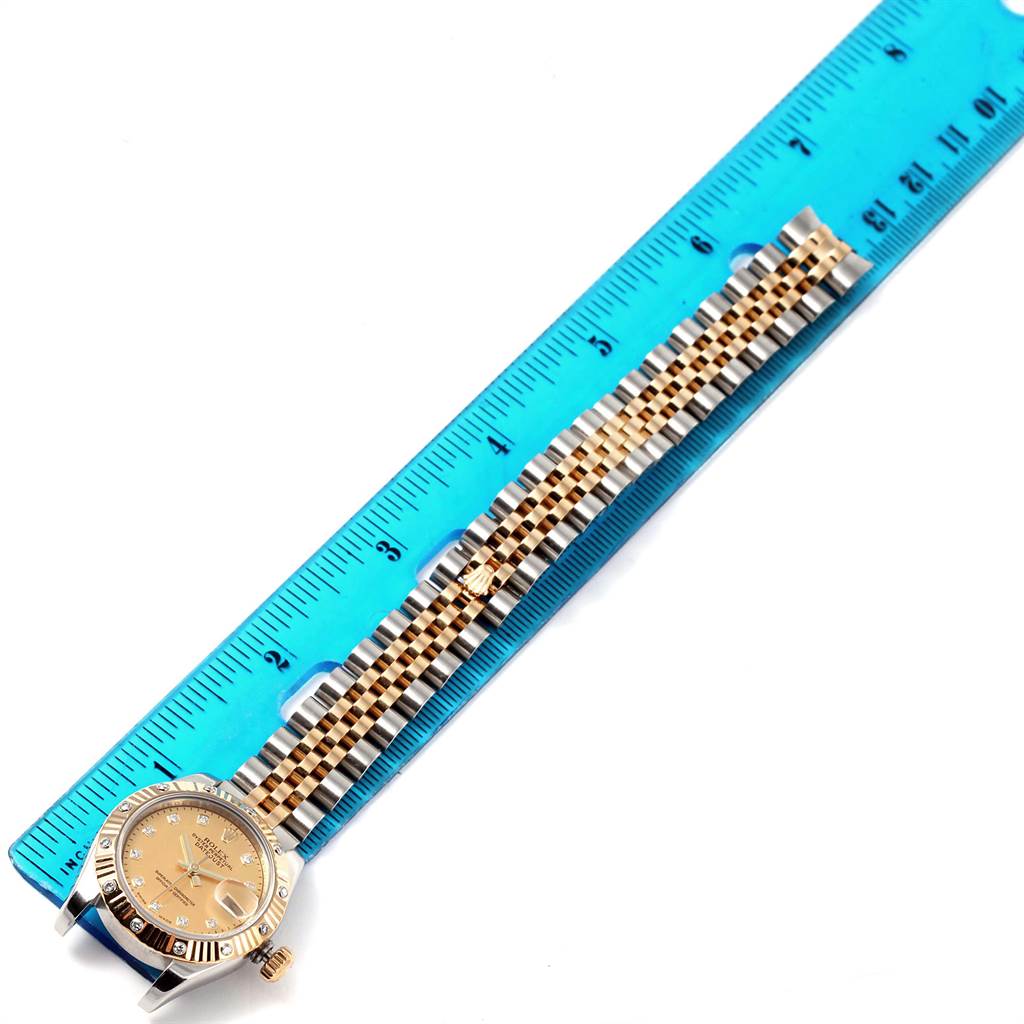 The Rolex Datejust 179313 Women's Stainless Steel Champagne Dial 179313 Women's Stainless Steel Champagne Dial watch is shown from a top-down angle, including the face and full bracelet beside a ruler for scale.