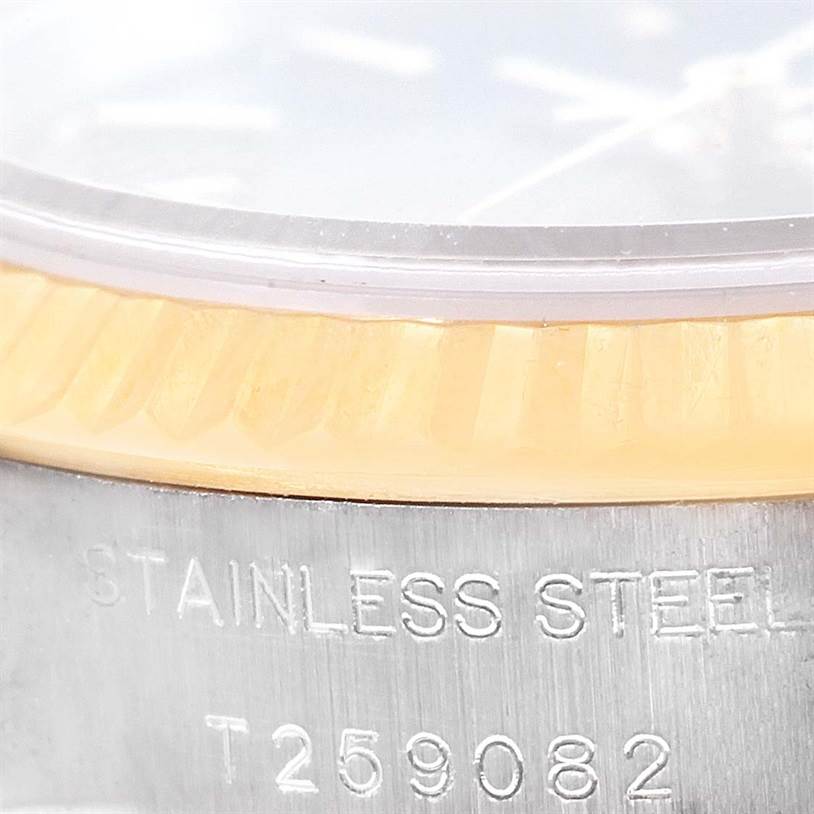 The image shows a close-up of the case side and fluted bezel of a Rolex Datejust 69173 Women's Stainless Steel Blue Dial 69173 Women's Stainless Steel Blue Dial watch with "STAINLESS STEEL" and a serial number engraved.