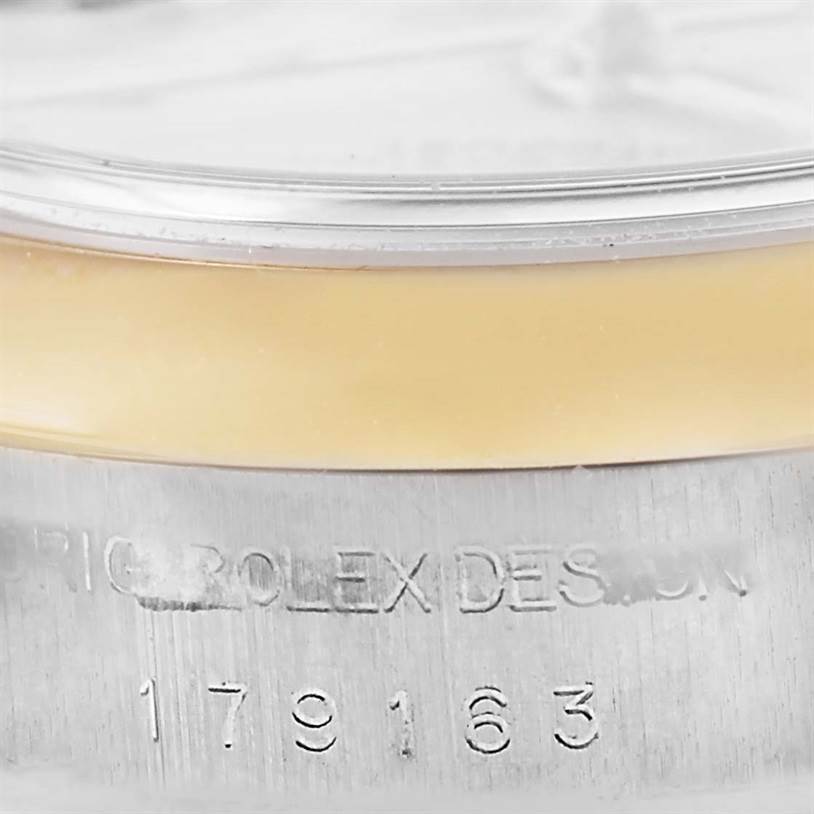 Close-up of a Rolex Datejust 179163 Women's Steel and Gold (two tone) Silver Dial 179163 Women's Steel and Gold (two tone) Silver Dial model showing part of the bezel and the engraved serial number on the case.
