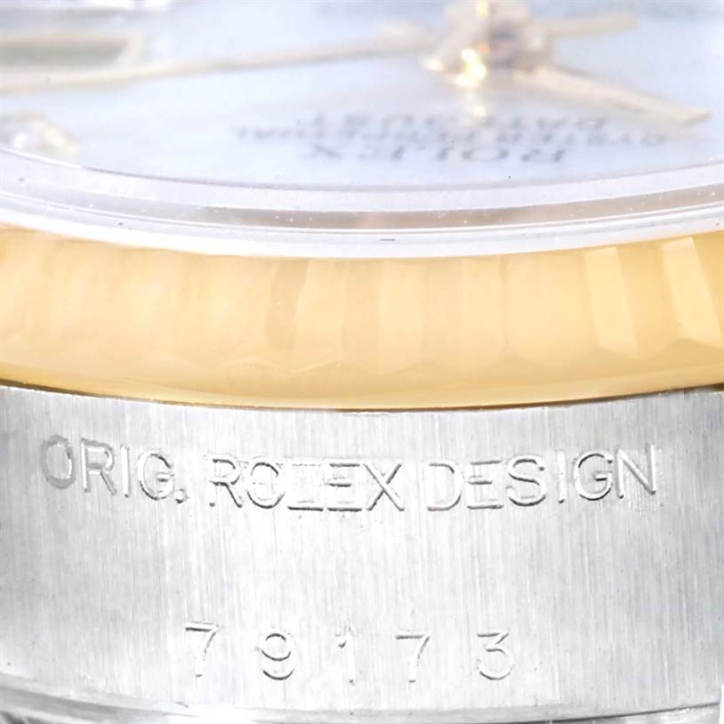 The image shows a close-up side view of a Rolex Datejust 79173 Women
s Stainless Steel Mother of Pearl Dial 79173 Women
s Stainless Steel Mother of Pearl Dial model, focusing on the bezel and engraved case.