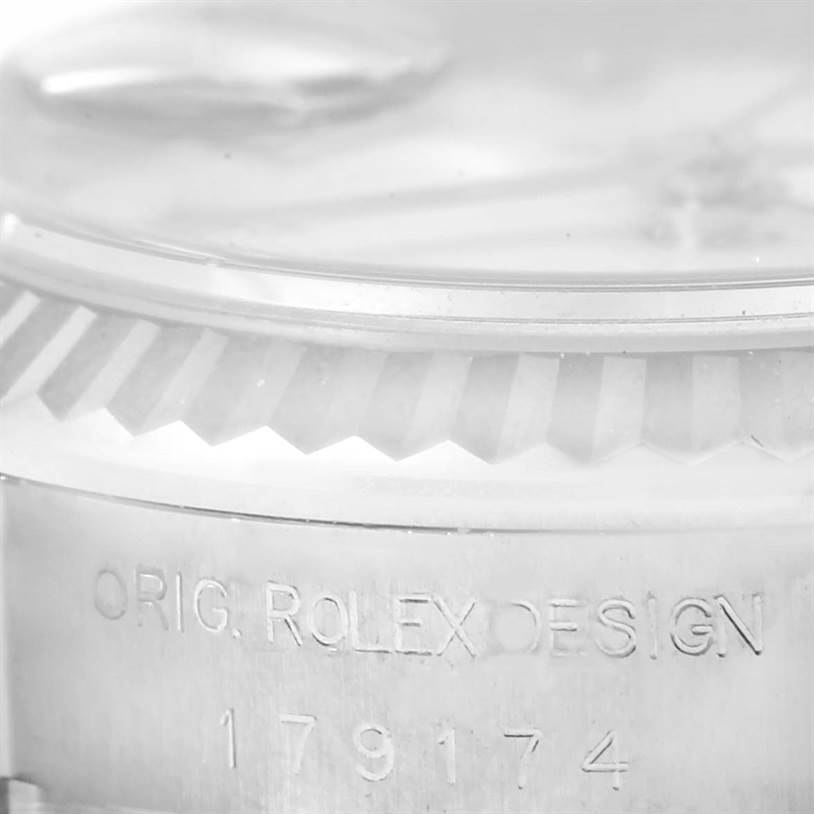 This close-up image of the Rolex Datejust 179174 Women's Stainless Steel White Dial 179174 Women's Stainless Steel White Dial watch shows the fluted bezel edge and engraved model number.