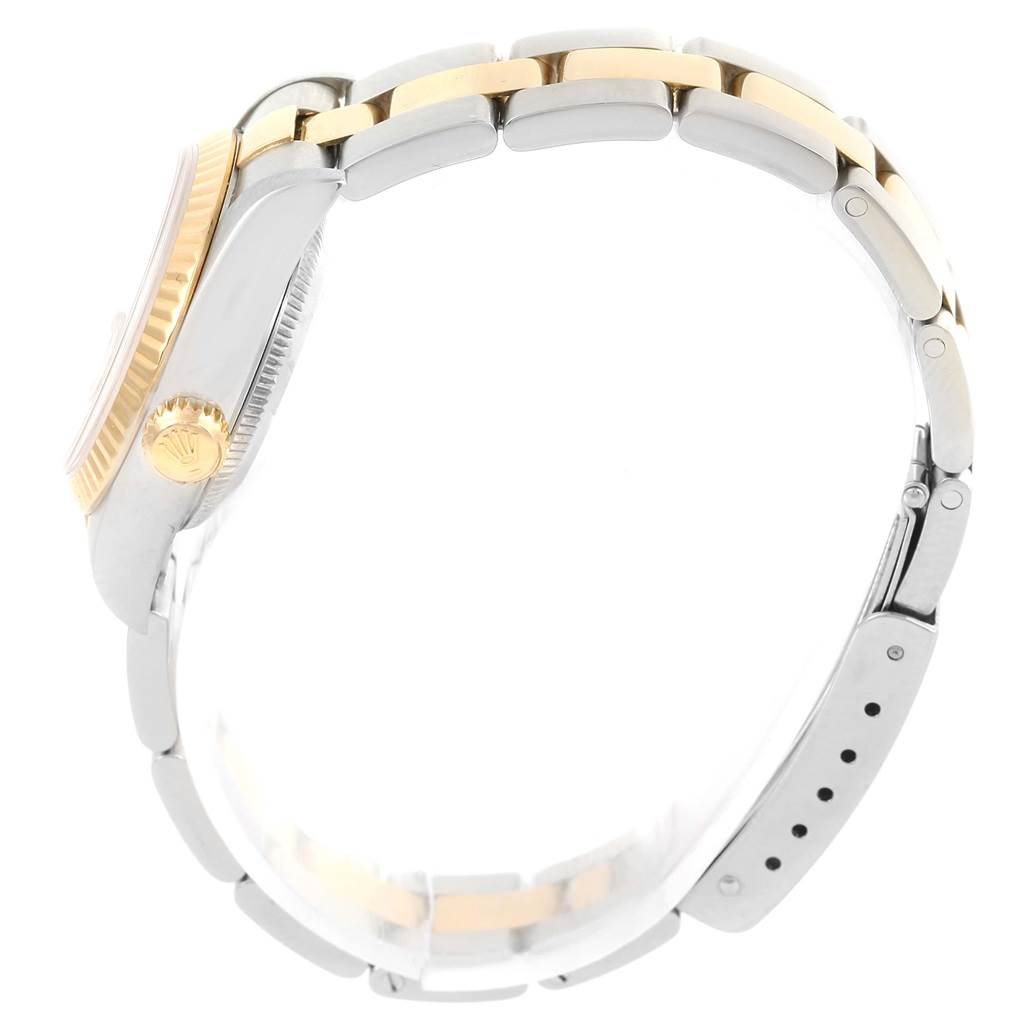 The image shows a side profile of the Rolex Datejust 79173 Women
s Stainless Steel Silver Dial 79173 Women
s Stainless Steel Silver Dial watch, highlighting the gold crown, fluted bezel, and two-tone bracelet.