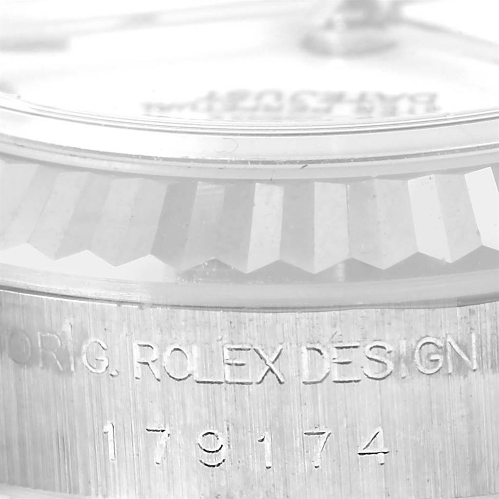 This image shows a close-up of the Rolex Datejust 179174 Women's Stainless Steel White Dial 179174 Women's Stainless Steel White Dial's case side engraving and fluted bezel edge.