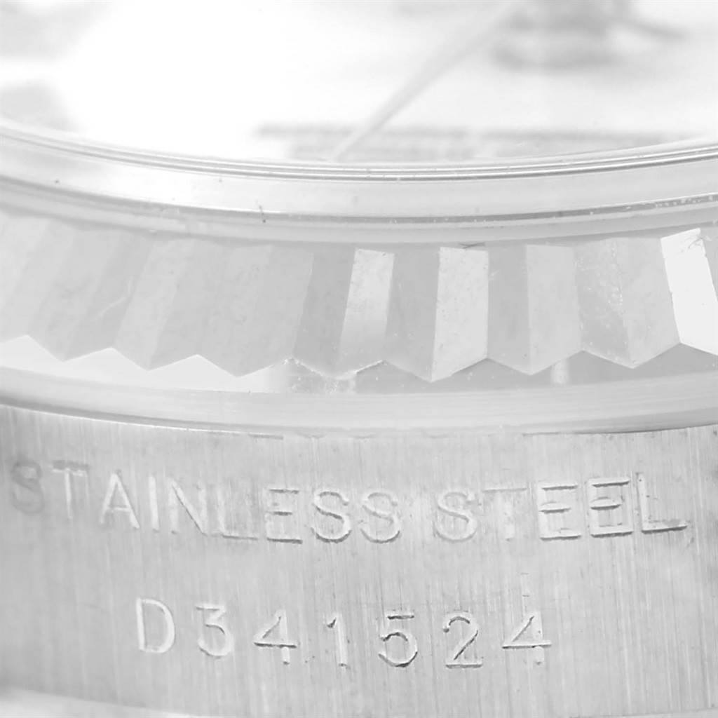 The image shows a close-up of the bezel and case side of a Rolex Datejust 179174 Women's Stainless Steel White Dial 179174 Women's Stainless Steel White Dial, highlighting the stainless steel material and serial number.