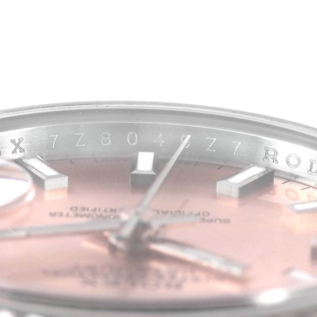 This close-up image of the Rolex Datejust 179174 Women's Stainless Steel Pink Dial 179174 Women's Stainless Steel Pink Dial watch shows the dial, hands, and part of the serial number on the inner bezel.