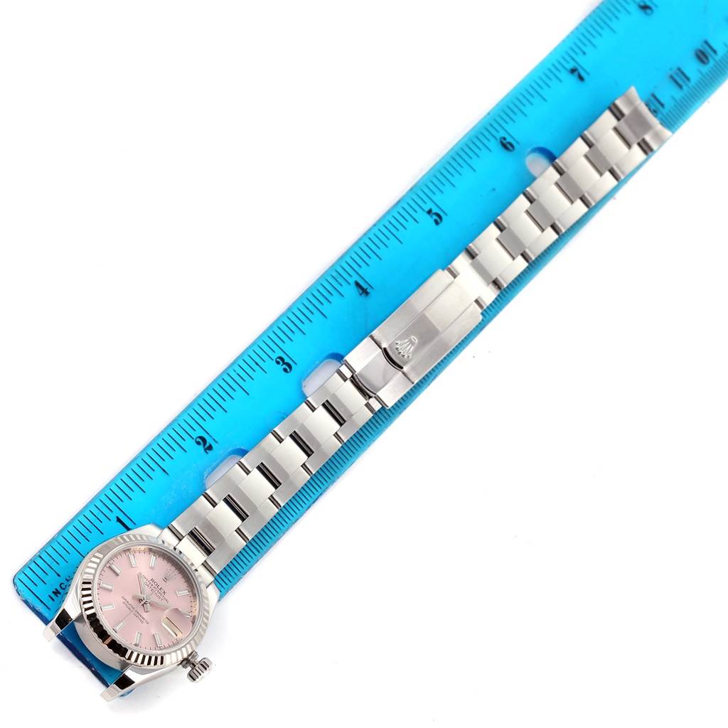 The image shows a Rolex Datejust 179174 Women's Stainless Steel Pink Dial 179174 Women's Stainless Steel Pink Dial watch laid flat with a blue ruler measuring its stainless steel bracelet.