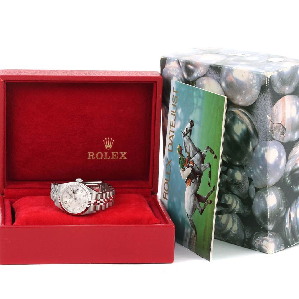 The image shows a Rolex Datejust 79174 Women
s Stainless Steel Silver Dial 79174 Women
s Stainless Steel Silver Dial watch in its red box, along with an instruction manual and outer packaging.