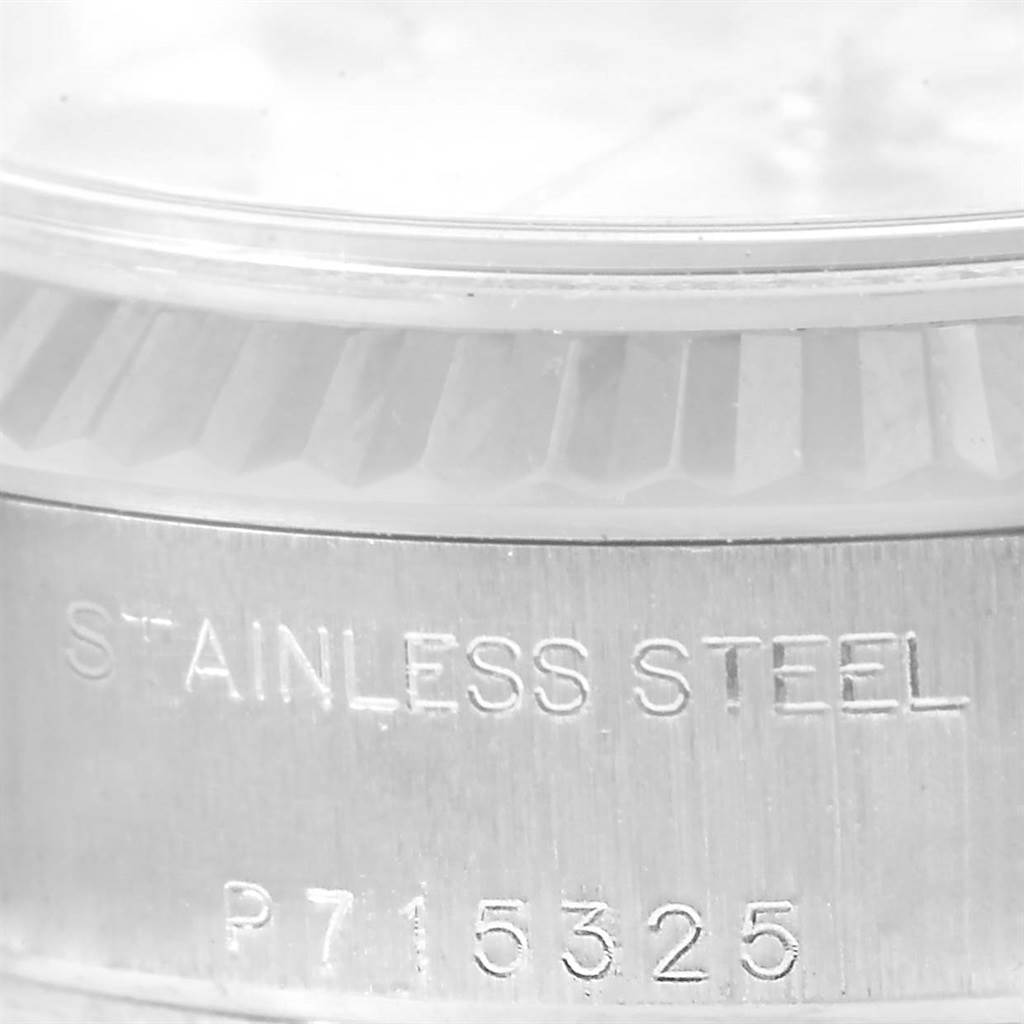 The image shows a close-up of the side of a stainless steel Rolex Datejust 79174 Women's Stainless Steel Silver Dial 79174 Women's Stainless Steel Silver Dial watch, featuring part of the bezel and engraved numbers.