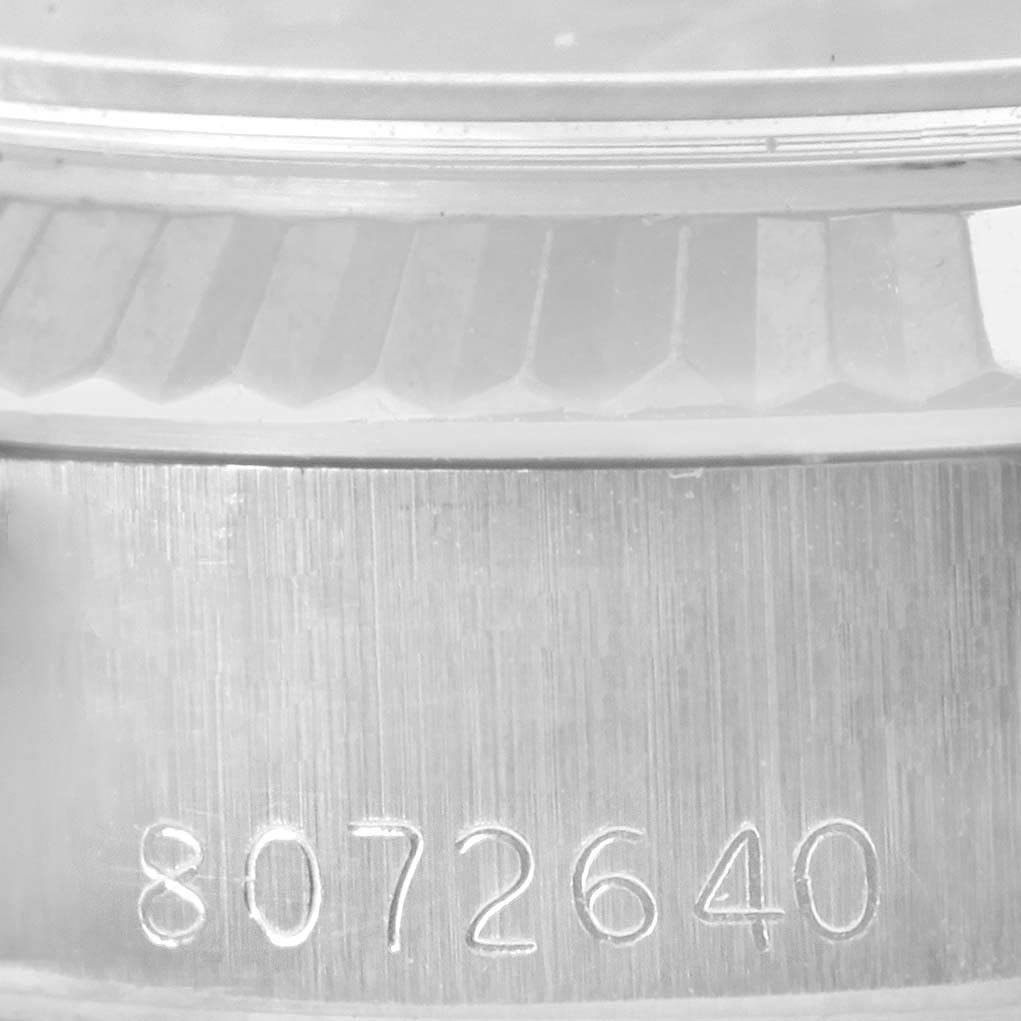 This close-up shot of a Rolex Datejust 69174 Women's Stainless Steel Pink Dial 69174 Women's Stainless Steel Pink Dial watch shows the model's engraved serial number and part of the bezel.