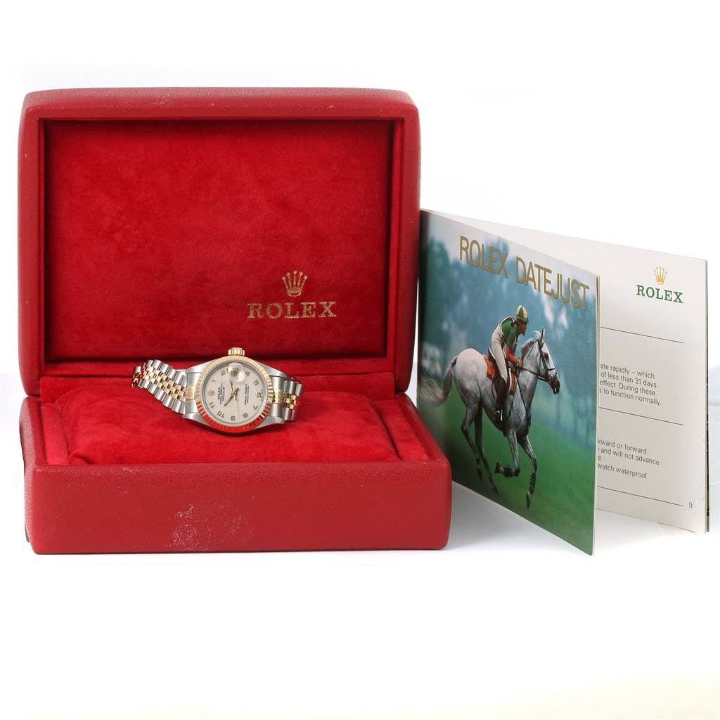 The Rolex Datejust 69173 Women's Stainless Steel Beige Dial 69173 Women's Stainless Steel Beige Dial watch is shown in an open red box, with its booklet positioned to the side.