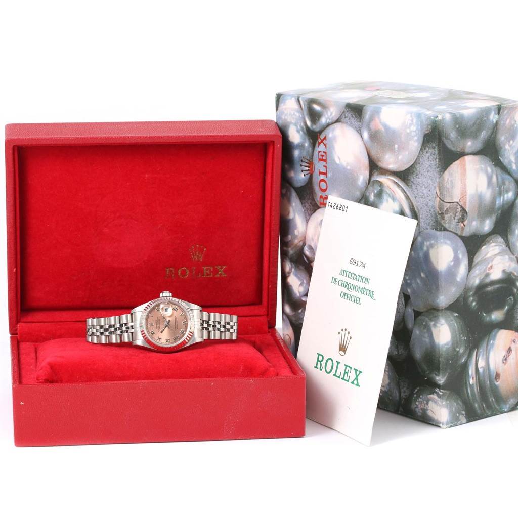 This image shows a Rolex Datejust 69174 Women
s Stainless Steel Pink Dial 69174 Women
s Stainless Steel Pink Dial watch in its box, along with papers and packaging.