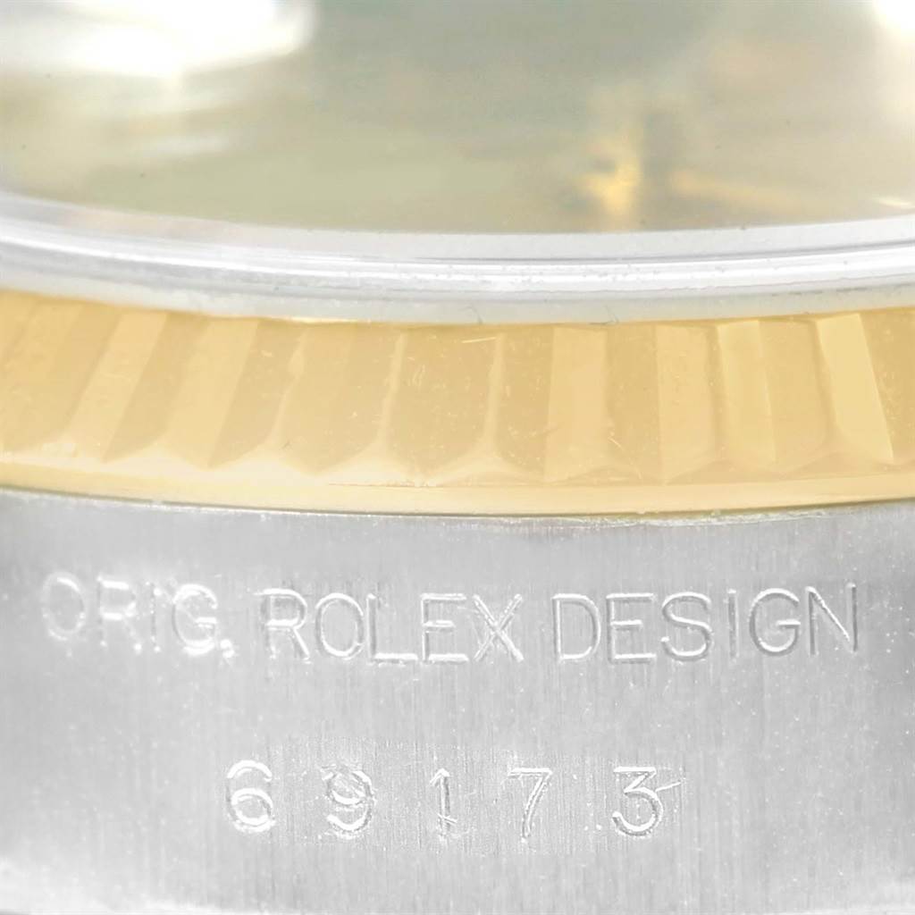 This close-up image shows the inscription and the fluted bezel of a Rolex Datejust 69173 Women's Stainless Steel Champagne Dial 69173 Women's Stainless Steel Champagne Dial watch.