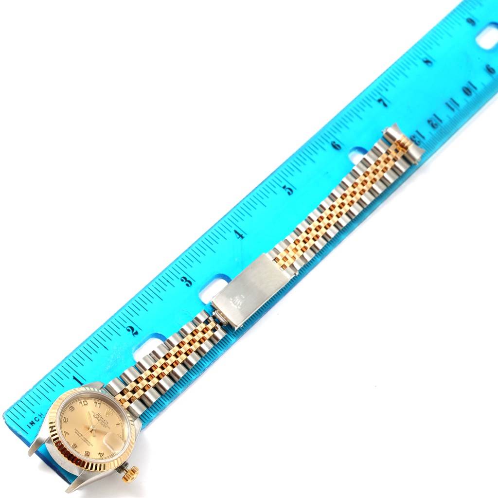 The image shows a Rolex Datejust 69173 Women's Stainless Steel Champagne Dial 69173 Women's Stainless Steel Champagne Dial watch from a top-down angle, displaying the face, crown, and band next to a blue ruler.