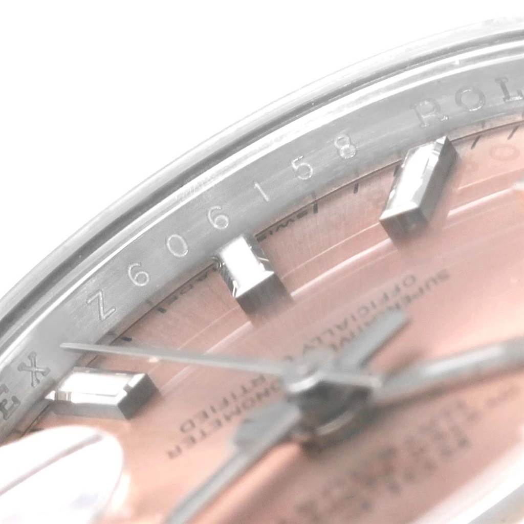 This close-up angle of the Rolex Datejust 179160 Women's Stainless Steel Pink Dial 179160 Women's Stainless Steel Pink Dial watch shows part of the dial, markers, hands, and the rehaut engraving.