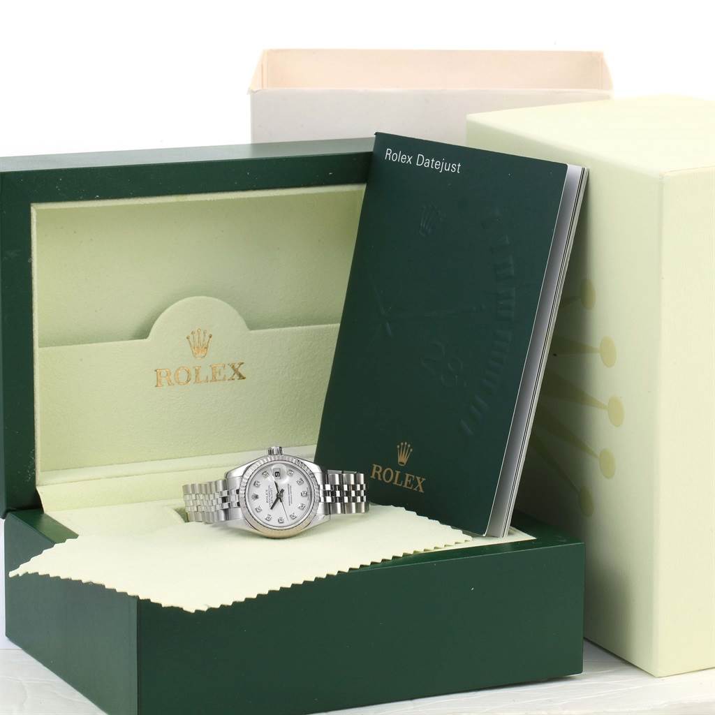 The image shows a Rolex Datejust 179174 Women
s Stainless Steel White Dial 179174 Women
s Stainless Steel White Dial watch with its box and manual, displayed at an angled view.