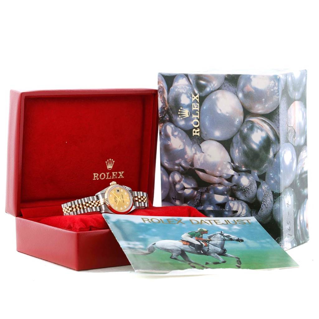 The image shows a Rolex Datejust 79163 Women's Steel and Gold (two tone) Champagne Dial 79163 Women's Steel and Gold (two tone) Champagne Dial watch, its red box, an outer box, and a manual featuring equestrian imagery.
