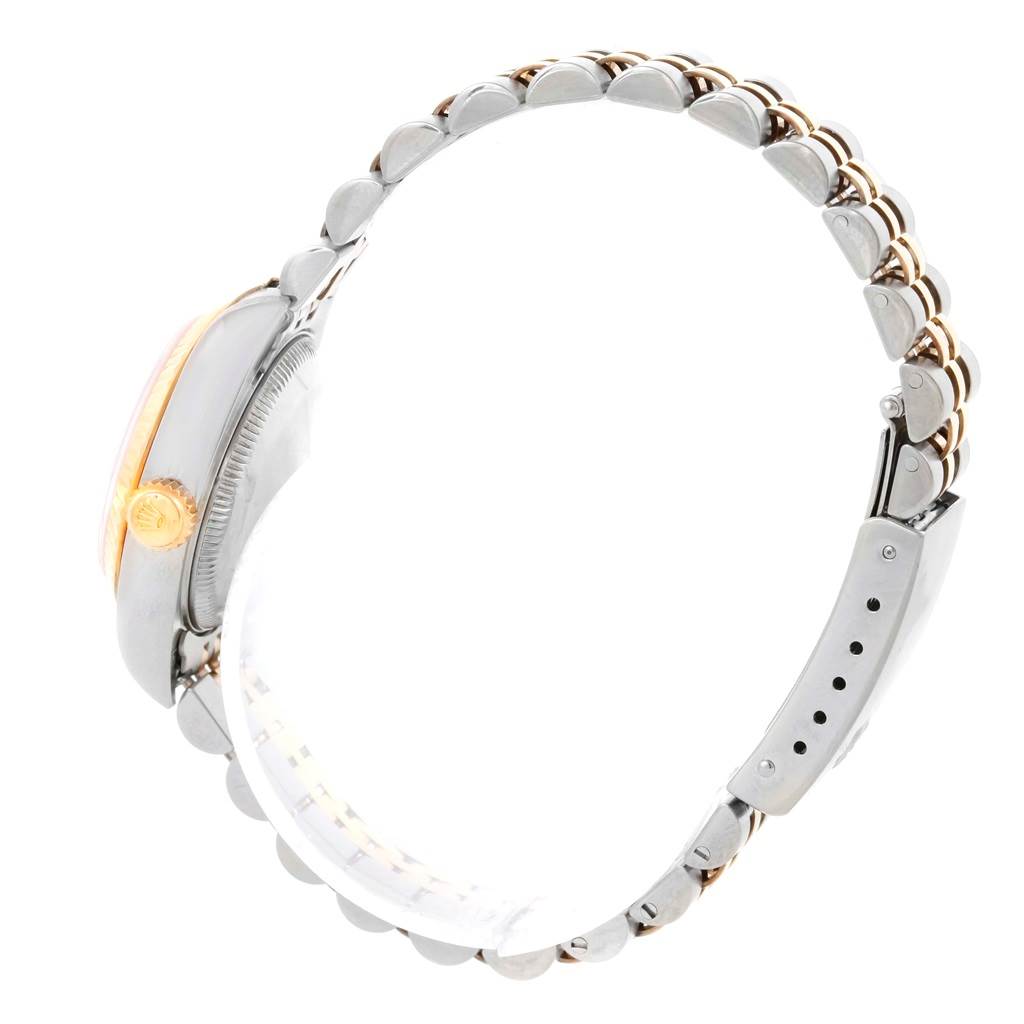 This side view of the Rolex Datejust 79163 Women's Steel and Gold (two tone) Champagne Dial 79163 Women's Steel and Gold (two tone) Champagne Dial watch shows the crown, case, and metal bracelet.