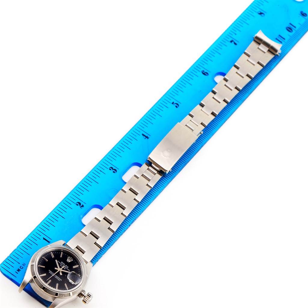 The image shows a Rolex Datejust 79190 Women's Stainless Steel Black Dial 79190 Women's Stainless Steel Black Dial watch laid flat, measured against a blue ruler, highlighting its band and face.