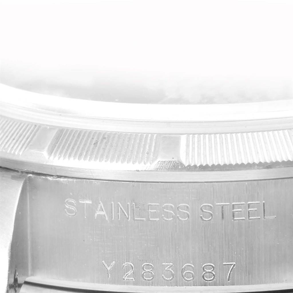 This image shows a close-up of the case side and bezel of a Rolex Datejust 79190 Women's Stainless Steel Black Dial 79190 Women's Stainless Steel Black Dial, with "STAINLESS STEEL" and a serial number engraved.