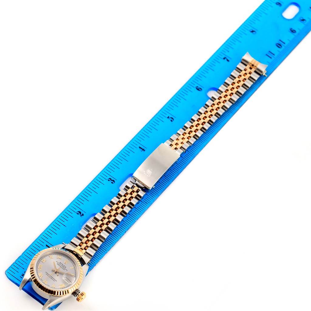 The Rolex Datejust 69173 Women's Stainless Steel Grey Dial 69173 Women's Stainless Steel Grey Dial watch is shown from a top-down angle, displaying its face, bezel, and bracelet aligned with a ruler.