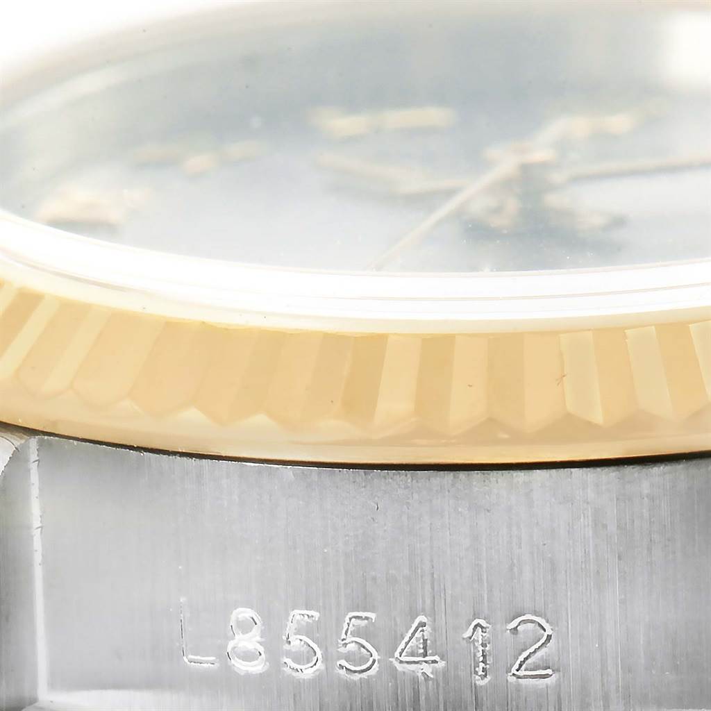 The image shows a close-up of the side of a Rolex Datejust 69173 Women's Stainless Steel Grey Dial 69173 Women's Stainless Steel Grey Dial watch, highlighting its serial number and fluted bezel.