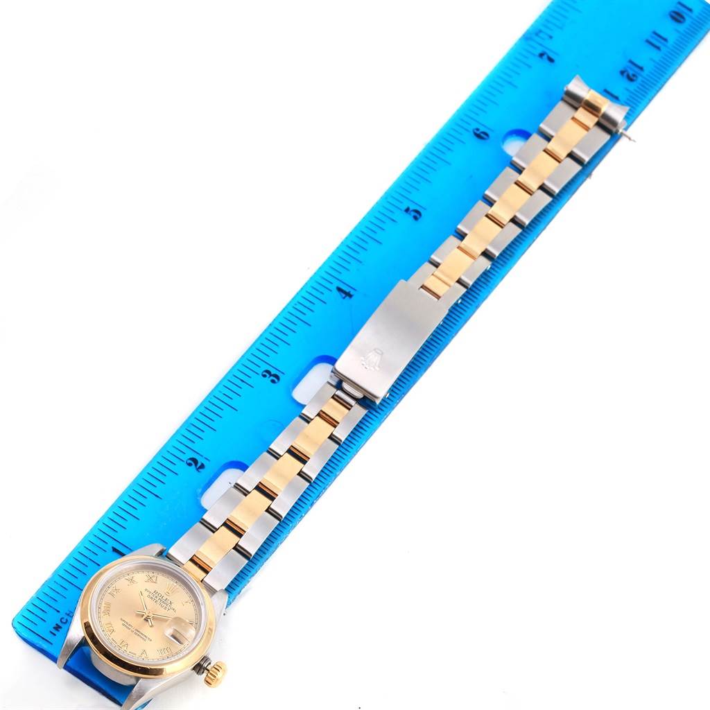 The image shows a Rolex 69163 Men
s Stainless Steel Champagne Dial 69163 Men
s Stainless Steel Champagne Dial Datejust Ladies Steel 18k Yellow Gold Roman Dial Watch 69163 model laid flat next to a ruler.