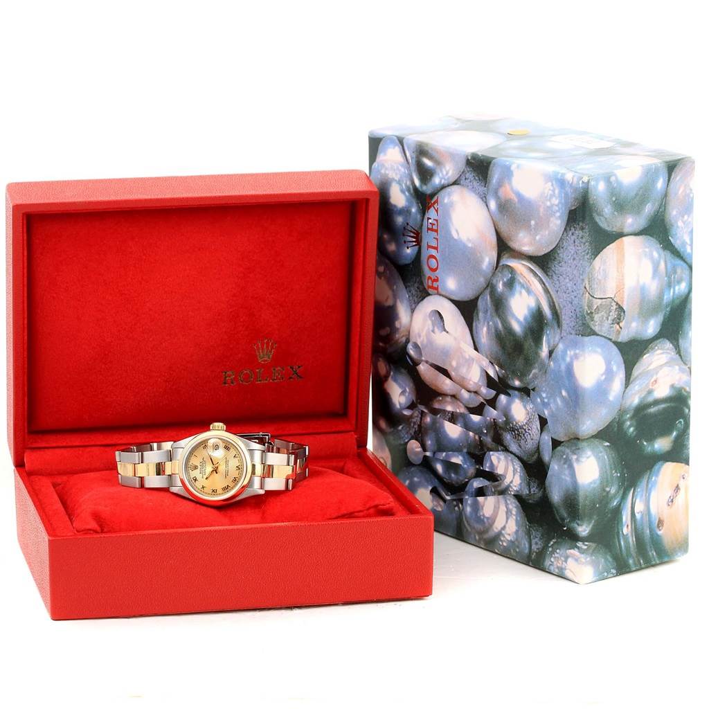 The Rolex 69163 Men
s Stainless Steel Champagne Dial 69163 Men
s Stainless Steel Champagne Dial Datejust Ladies Steel 18k Yellow Gold Roman Dial Watch 69163 model is shown in its open red box next to its decorative outer box.