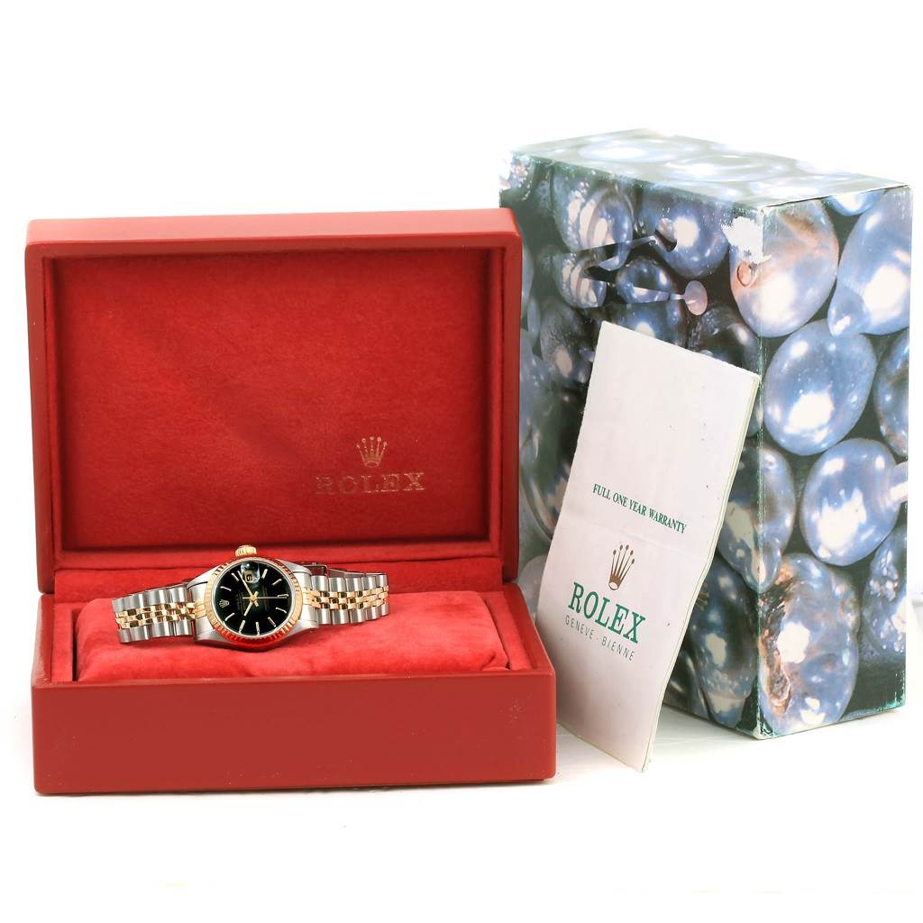 The image shows a Rolex Datejust 69173 Women's Stainless Steel Black Dial 69173 Women's Stainless Steel Black Dial watch with a black dial, displayed inside a red box with an accessory booklet to the side.