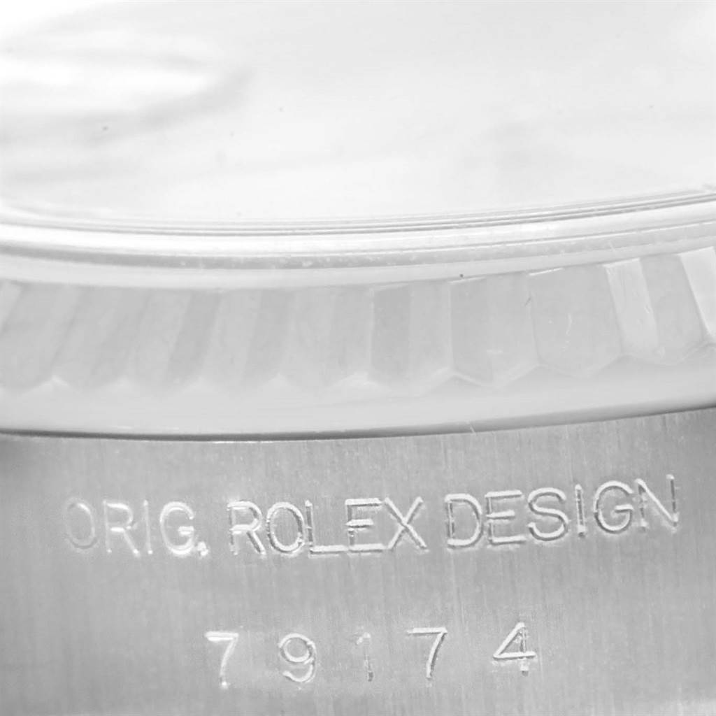 The image shows a close-up of the side of a Rolex Datejust 79174 Women's Stainless Steel Mother of Pearl Dial 79174 Women's Stainless Steel Mother of Pearl Dial watch, highlighting the "ORIG. ROLEX DESIGN" engraving and model number 79174.