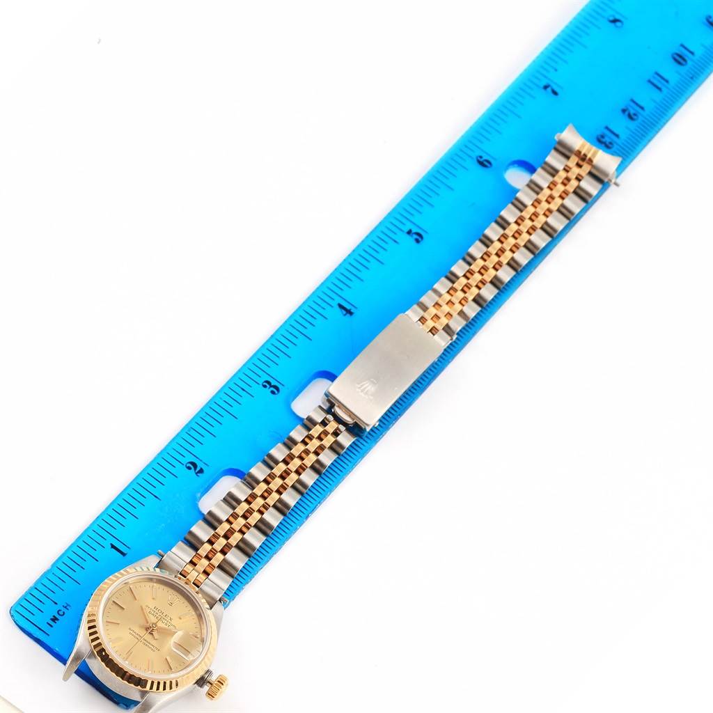 The Rolex Datejust 69173 Women's Stainless Steel Champagne Dial 69173 Women's Stainless Steel Champagne Dial watch is shown from a top-down angle alongside a blue ruler, displaying the face and bracelet.