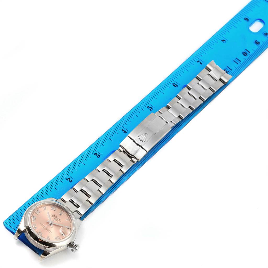 A Rolex Datejust 178240 Women
s Stainless Steel Pink Dial 178240 Women
s Stainless Steel Pink Dial watch is shown from the top view, placed next to a blue ruler, highlighting the bracelet and clasp.