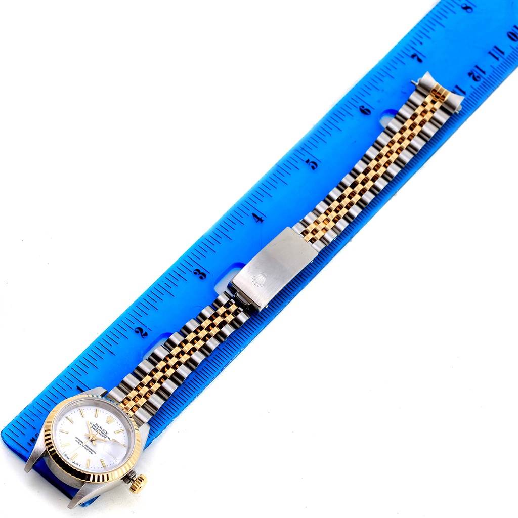 The image shows a Rolex Datejust 69173 Women's Stainless Steel White Dial 69173 Women's Stainless Steel White Dial watch laid flat, aligned with a blue ruler, displaying the watch face, bracelet, and clasp.