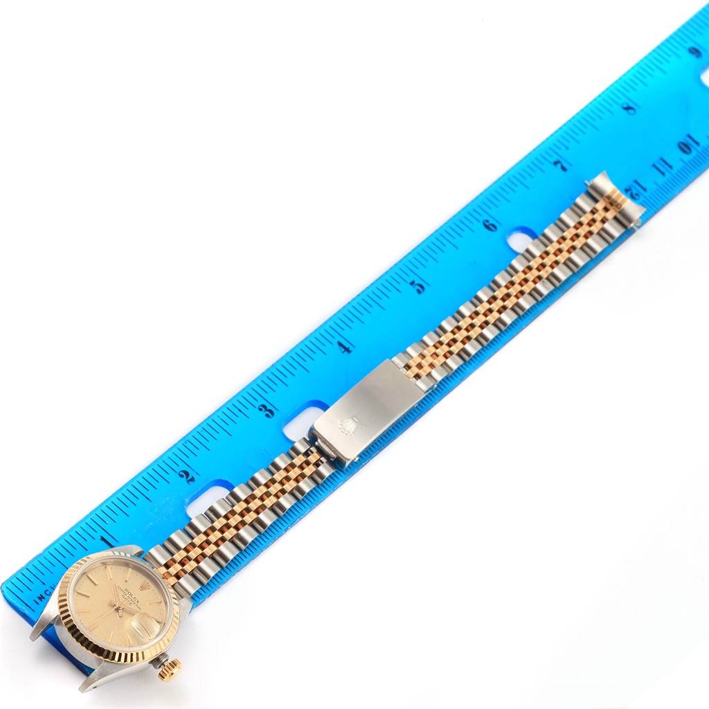 The image shows a Rolex Datejust 69173 Women
s Stainless Steel Champagne Dial 69173 Women
s Stainless Steel Champagne Dial watch laid flat with its face and bracelet visible next to a blue ruler.