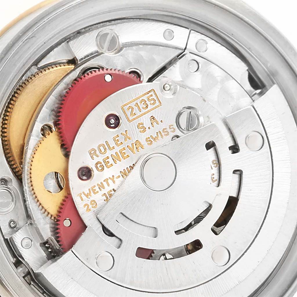 This close-up image shows the intricate internal mechanisms of a Rolex Datejust 69173 Women
s Stainless Steel Black Dial 69173 Women
s Stainless Steel Black Dial model, highlighting its gears and engravings.