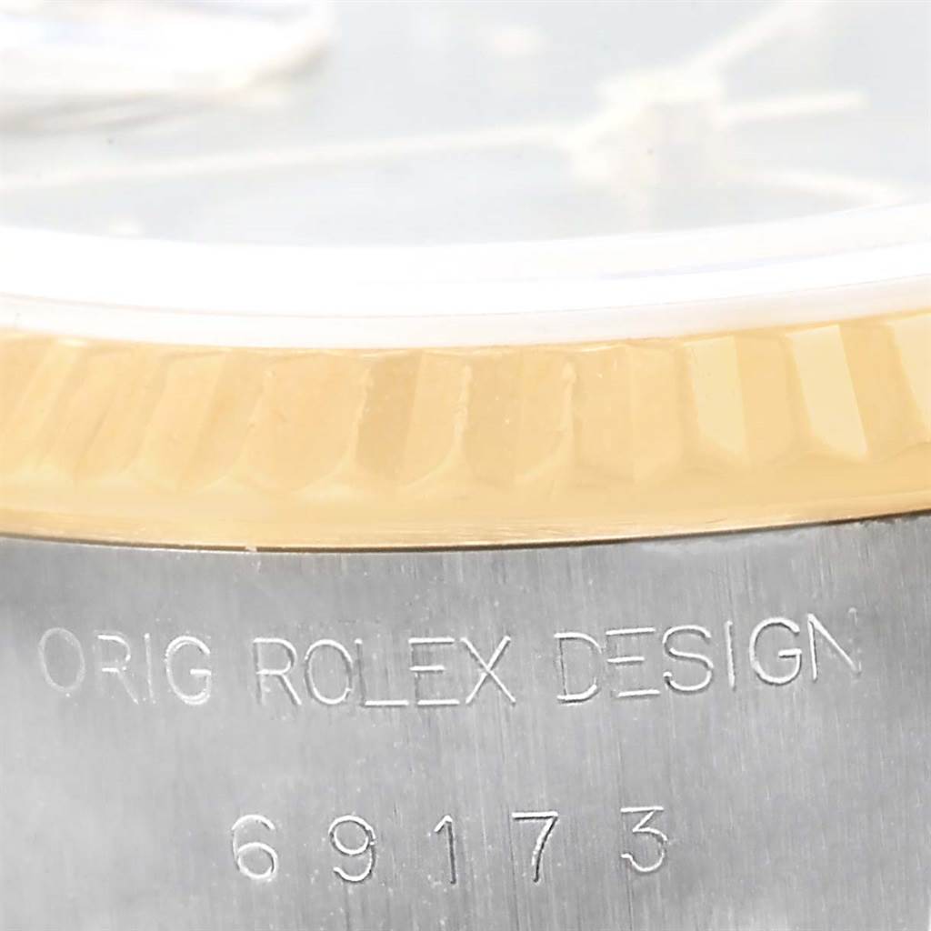 The image shows a close-up of the edge of a Rolex Datejust 69173 Women's Stainless Steel Black Dial 69173 Women's Stainless Steel Black Dial watch, highlighting the bezel and engraved model number.