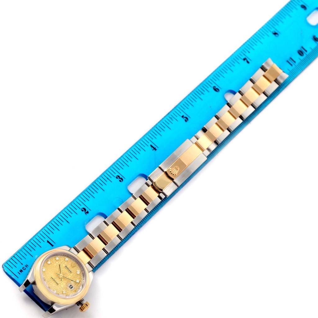 The image shows a Rolex Datejust 179163 Women's Steel and Gold (two tone) Champagne Dial 179163 Women's Steel and Gold (two tone) Champagne Dial watch, featuring the face and band next to a blue ruler for size reference.
