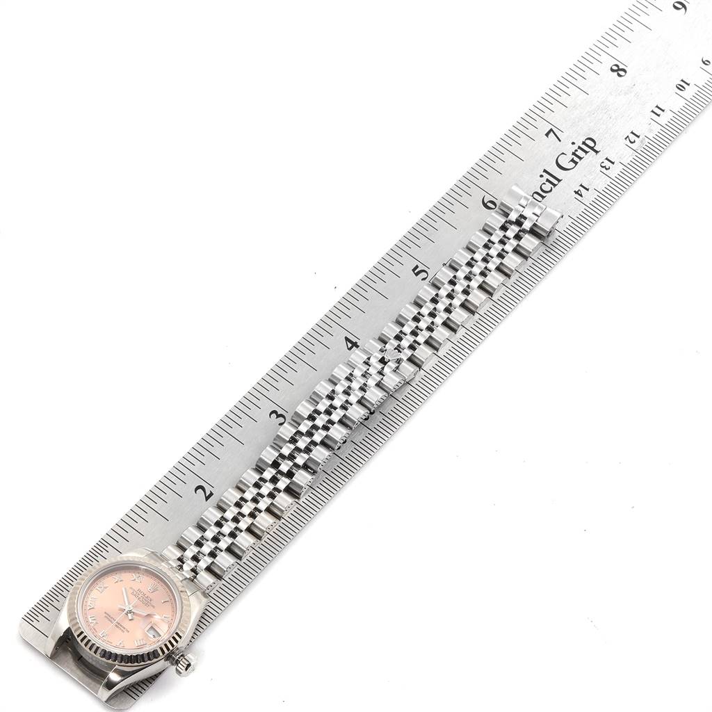 The image shows a partially visible Rolex Datejust 179174 Women's Stainless Steel Pink Dial 179174 Women's Stainless Steel Pink Dial watch with a pink dial and stainless steel Jubilee bracelet, alongside a ruler.