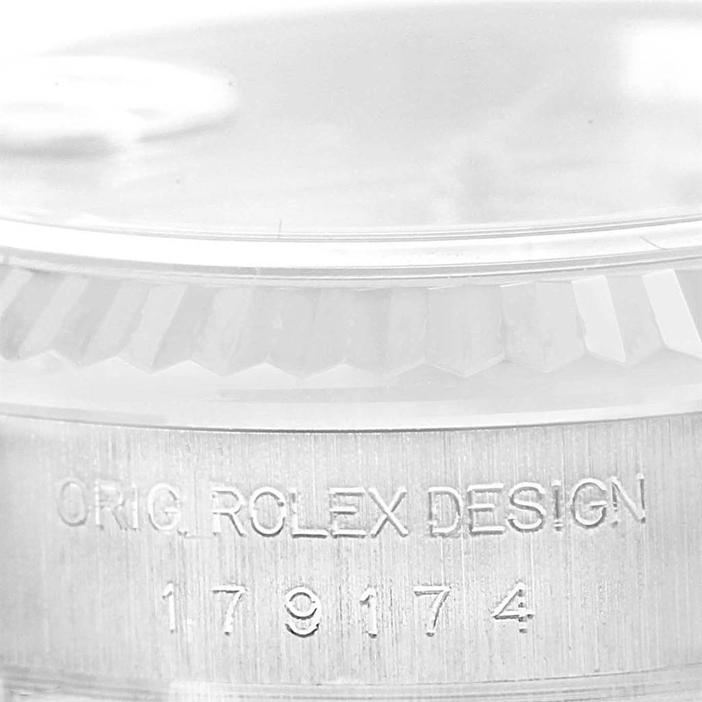 The image shows a close-up of the side of a Rolex Datejust 179174 Women's Stainless Steel Pink Dial 179174 Women's Stainless Steel Pink Dial watch, highlighting the engraved text and part of the fluted bezel.