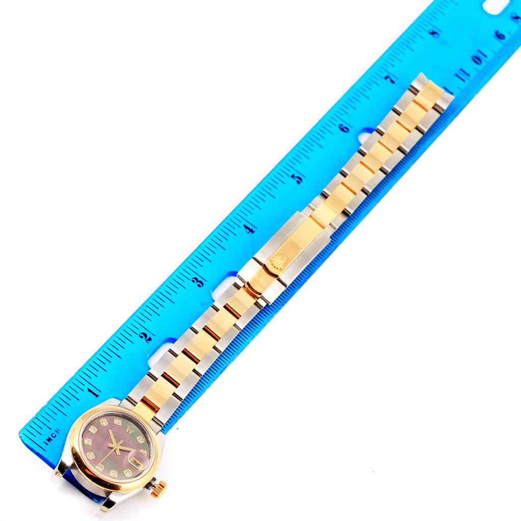 The image shows a Rolex Datejust 179163 Women's Steel and Gold (two tone) Mother of Pearl Dial 179163 Women's Steel and Gold (two tone) Mother of Pearl Dial watch laid flat next to a blue ruler, displaying its face and entire band.