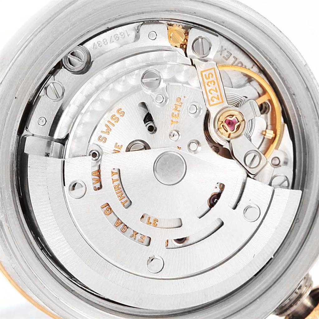 This image shows the internal mechanism of the Rolex Datejust 179173 Women's Steel and Gold (two tone) Champagne Dial 179173 Women's Steel and Gold (two tone) Champagne Dial watch, including gears, screws, and the balance wheel.