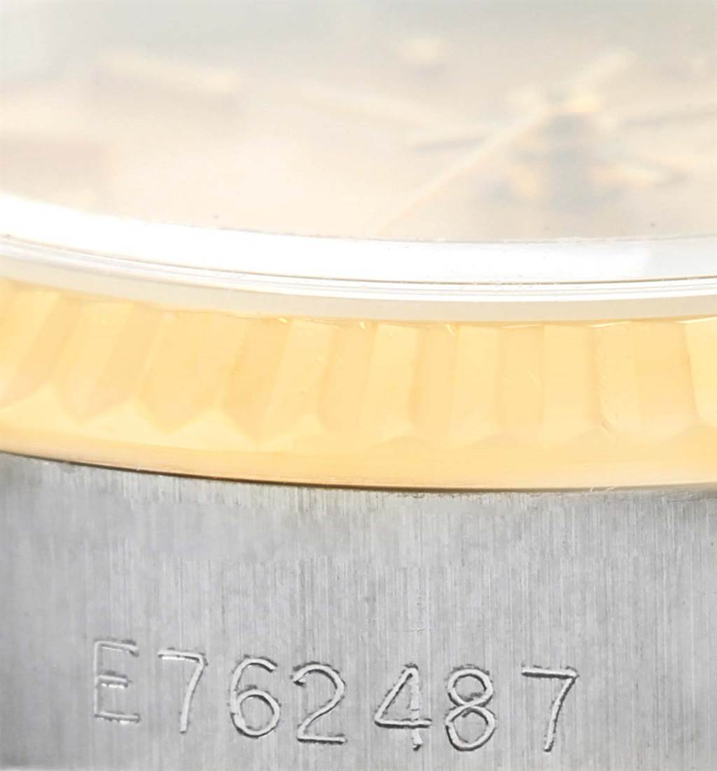 The image shows a close-up of the side of a Rolex Datejust 69173 Women
s Stainless Steel Champagne Dial 69173 Women
s Stainless Steel Champagne Dial watch, highlighting the bezel and engraved serial number.