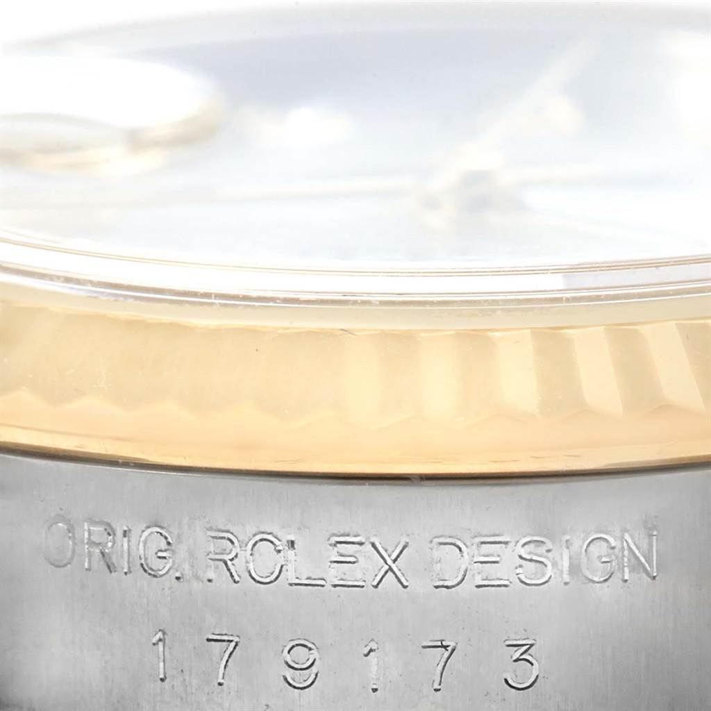 This image shows a close-up of the side of a Rolex Datejust 179173 Women's Steel and Gold (two tone) Mother of Pearl Dial 179173 Women's Steel and Gold (two tone) Mother of Pearl Dial watch, highlighting the bezel and engraving on the case.