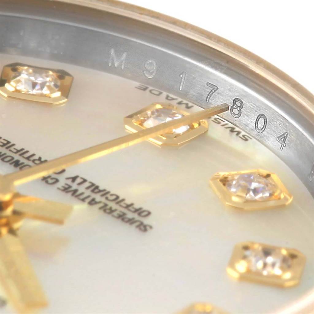 This close-up image of a Rolex Datejust 179173 Women's Steel and Gold (two tone) Mother of Pearl Dial 179173 Women's Steel and Gold (two tone) Mother of Pearl Dial watch shows diamond hour markers, the hands, and part of the inner bezel with engraved numbers.